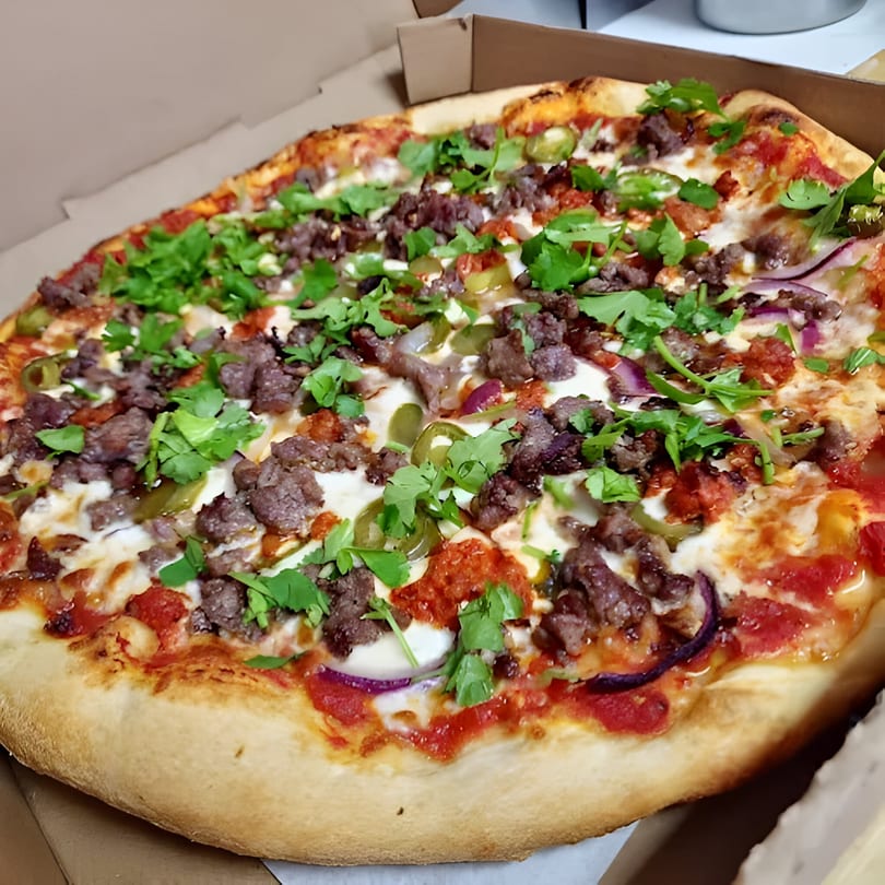 A Bianco's Italian Cuisine pizza with ground meat, red onions, jalapeños, and cilantro in a box.
