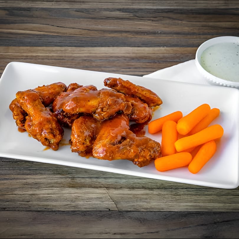Bianco's Italian Cuisine's buffalo wings with baby carrots and a side of ranch dressing.