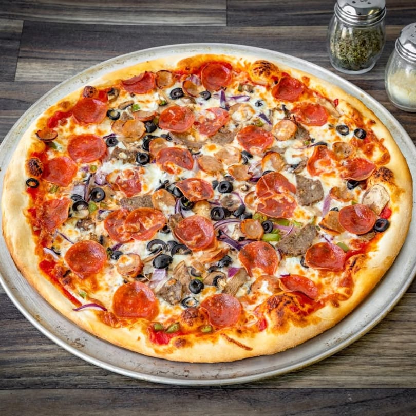 A large, round Bianco's Italian Cuisine pizza with pepperoni, sausage, olives, and mushrooms.